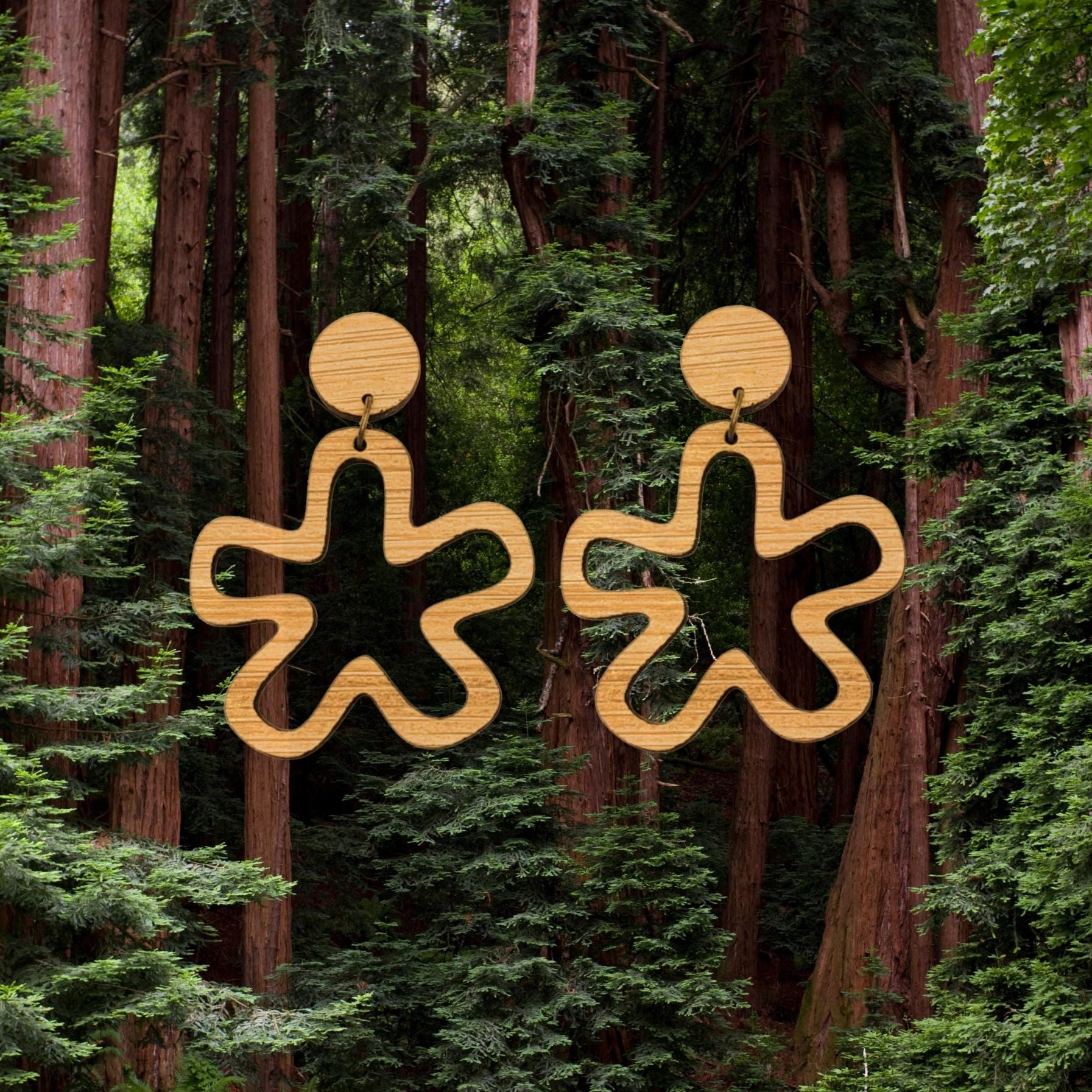 abstract star cut out earring behind a forest background