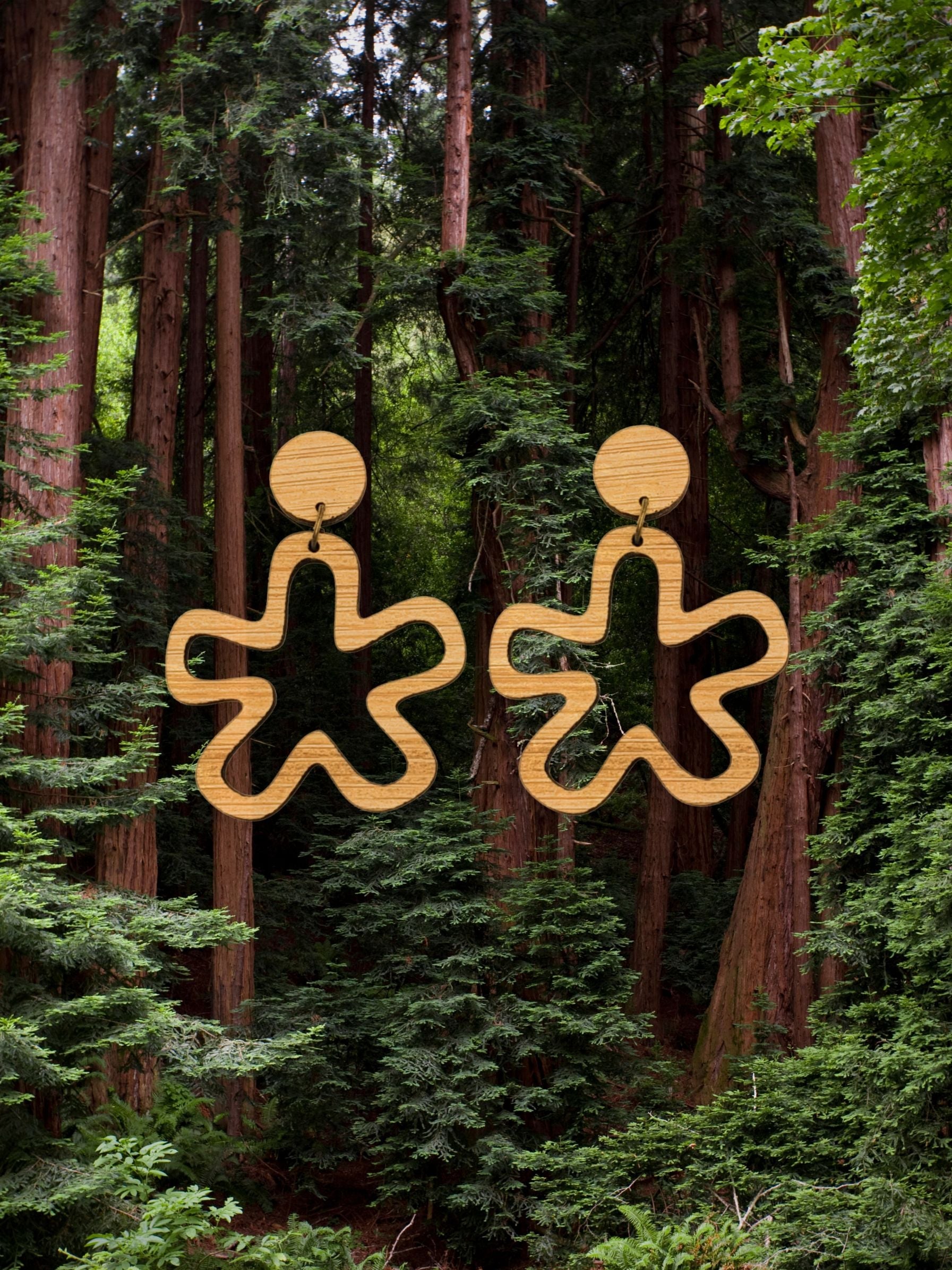 abstract star cut out earring behind a forest background