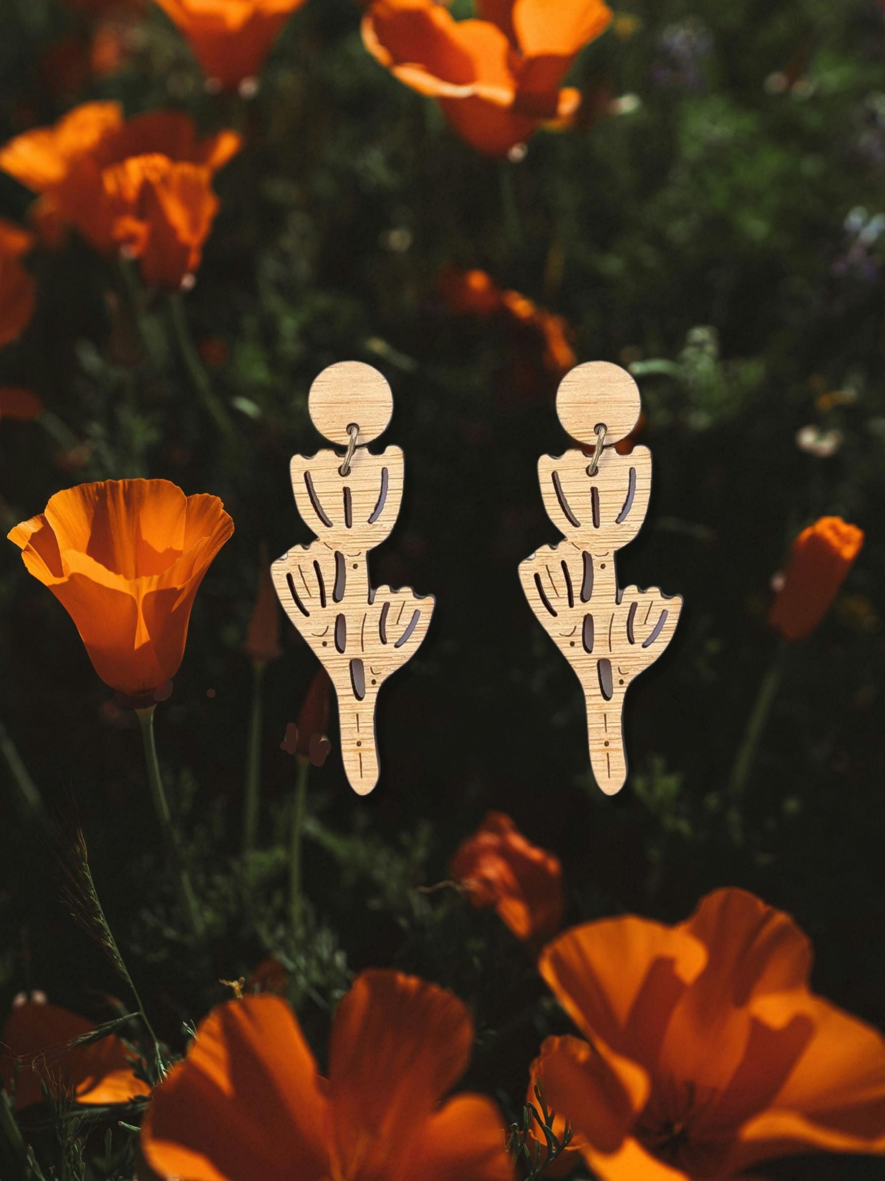 laser cut poppy dangles earring s on a photo of a california poppy field