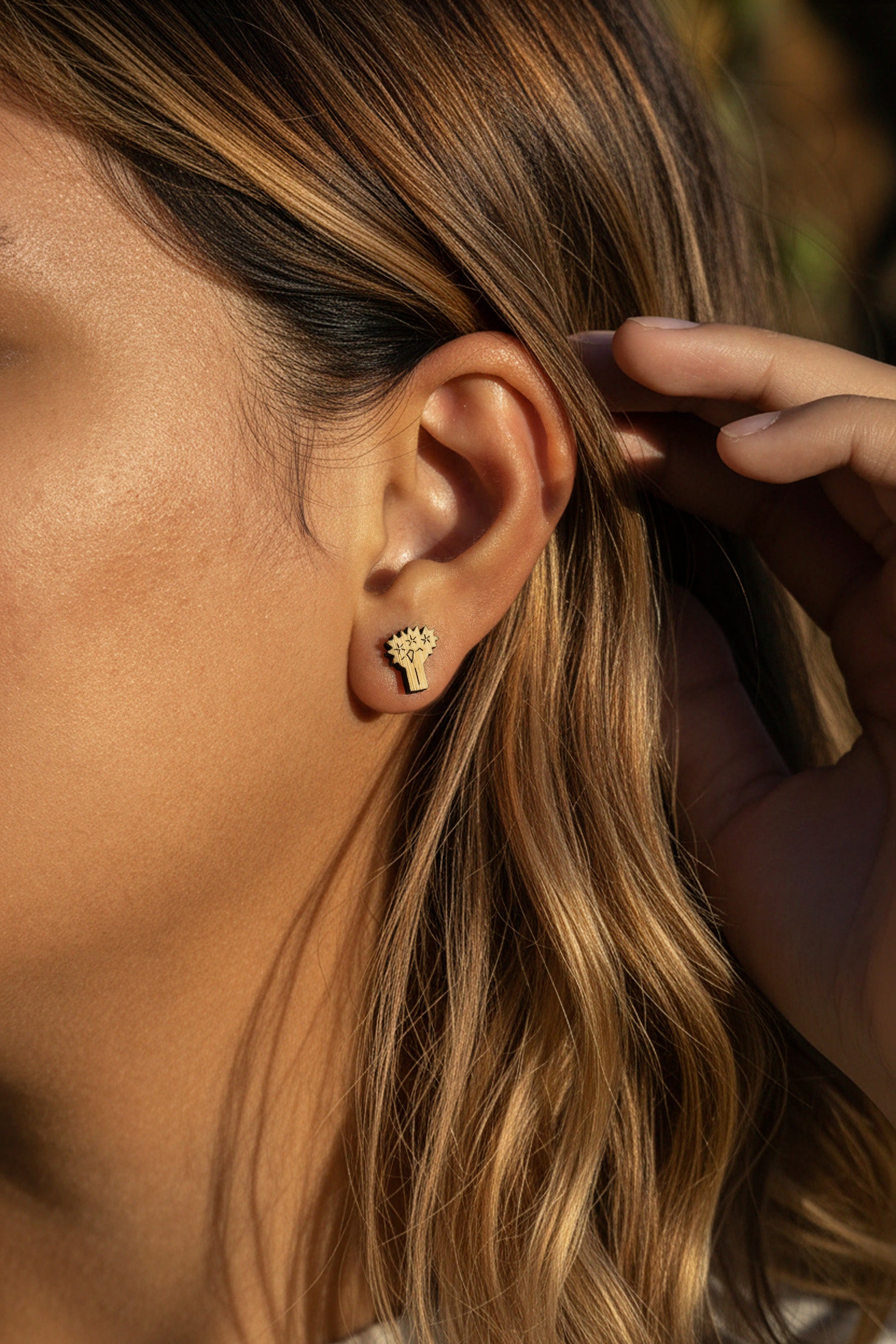 a women wearing bamboo joshua tree earrings on a blurred background