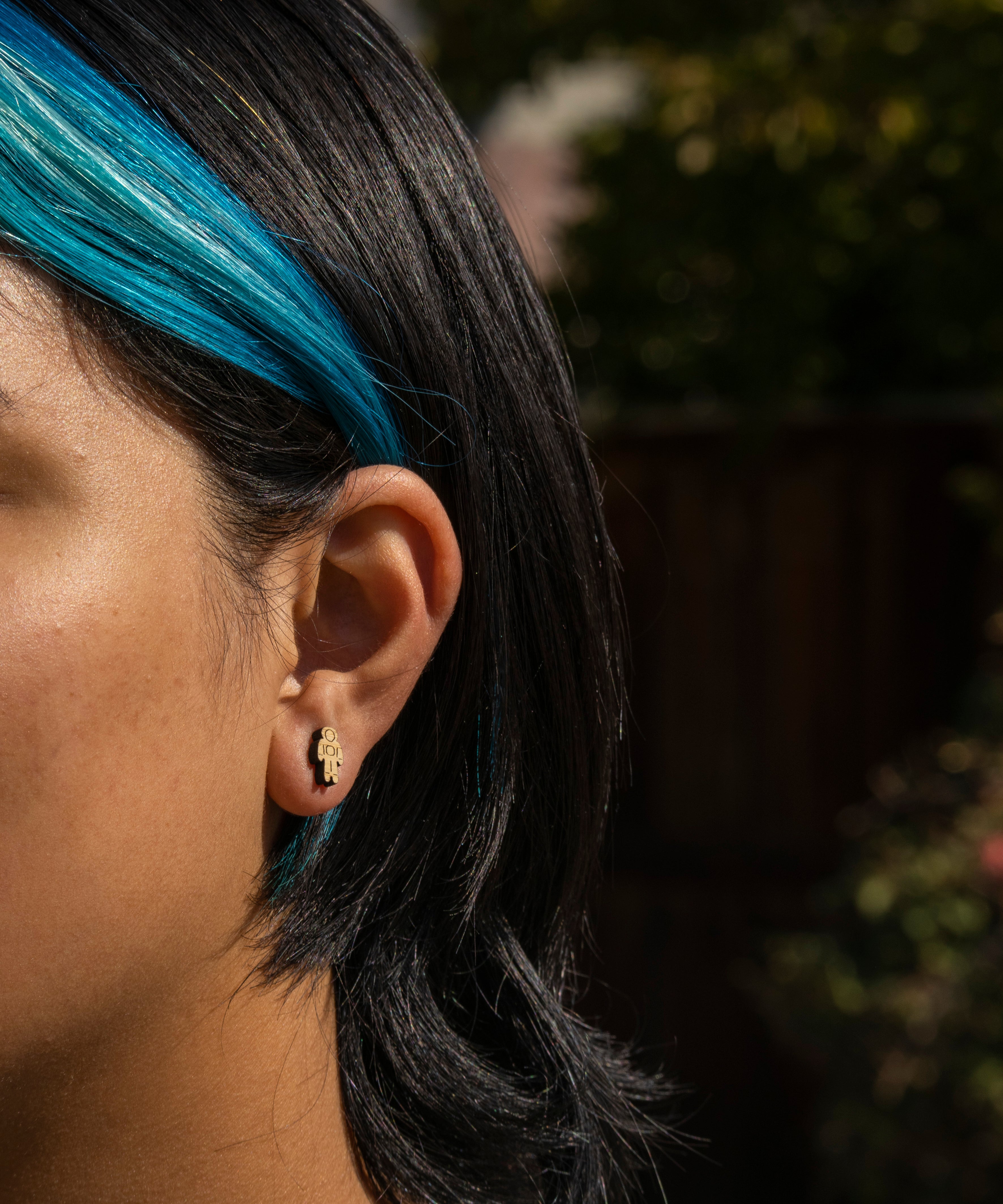 person wearing cute astronaut bamboo stud earrings