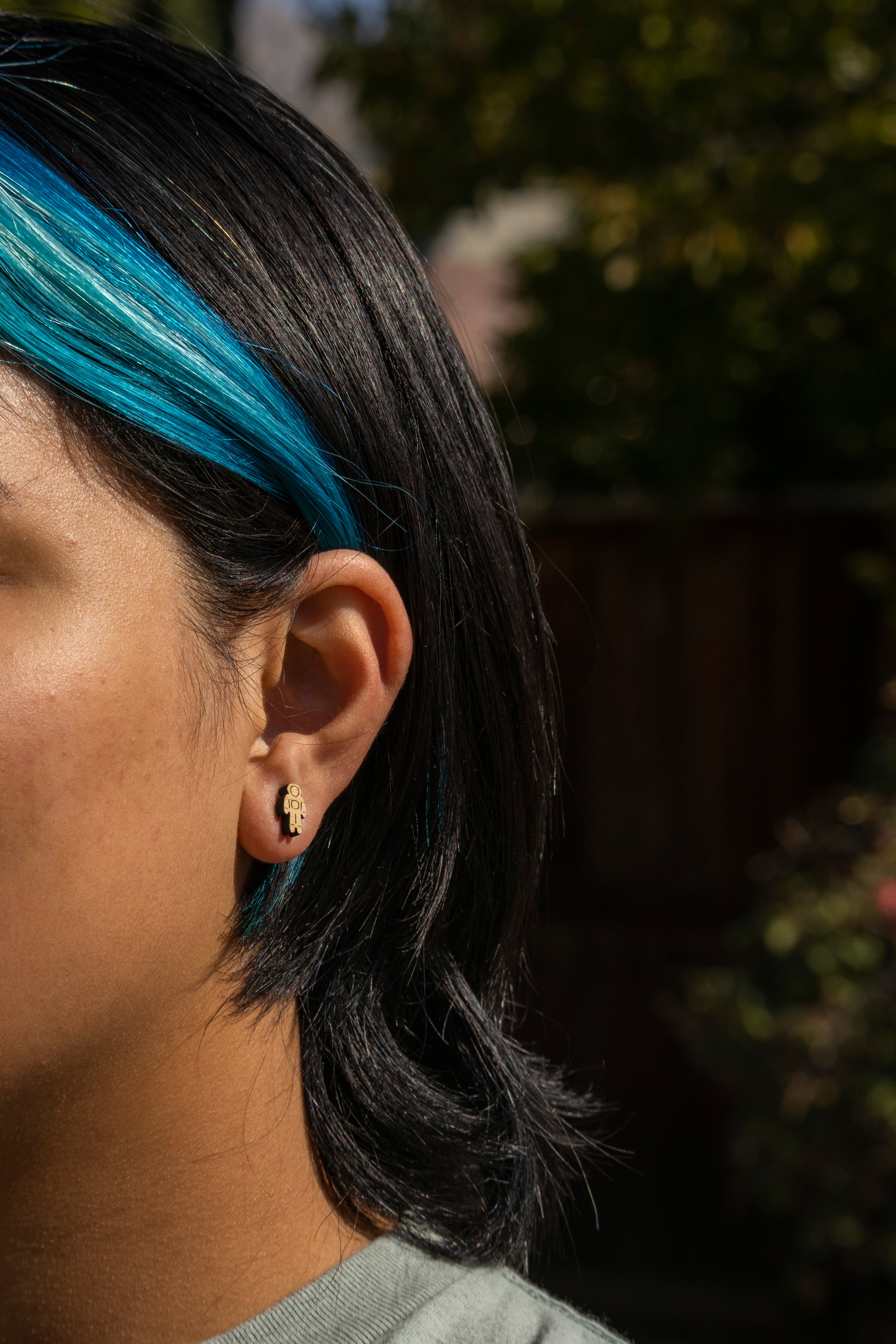 person wearing cute astronaut bamboo stud earrings