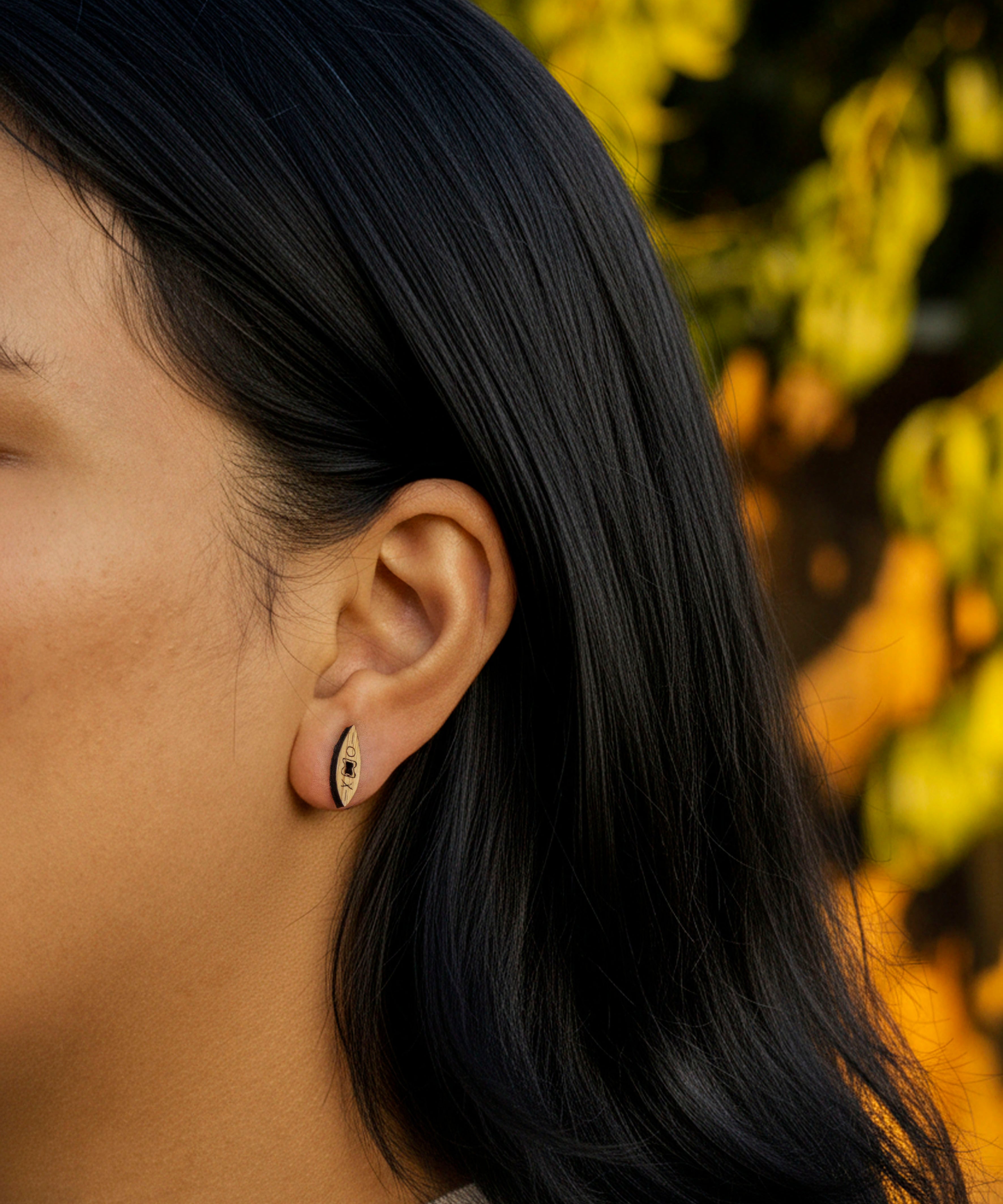 person wearing kayak wood earring on a natural background