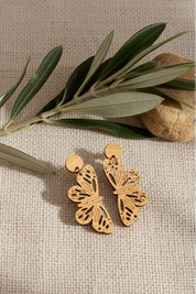 monarch dangles wood earrings on linen background