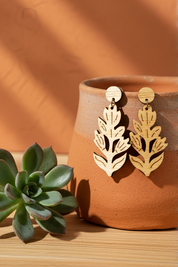 wood paintbrush flower drop earrings on a terracotta pot with a succulent plant