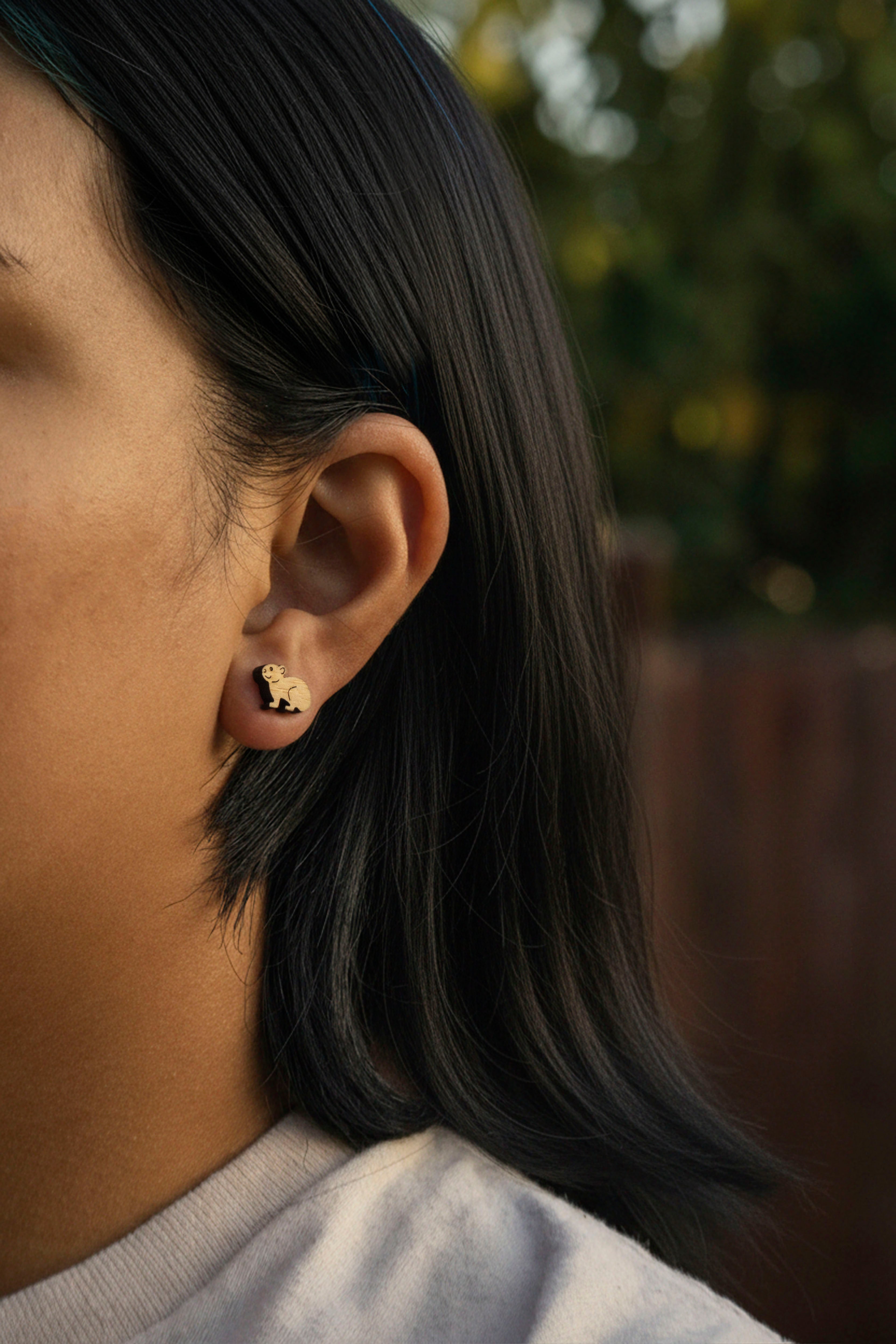 Close-up of a person wearing a cute pika stud hypoallergenic earring with a blurred background