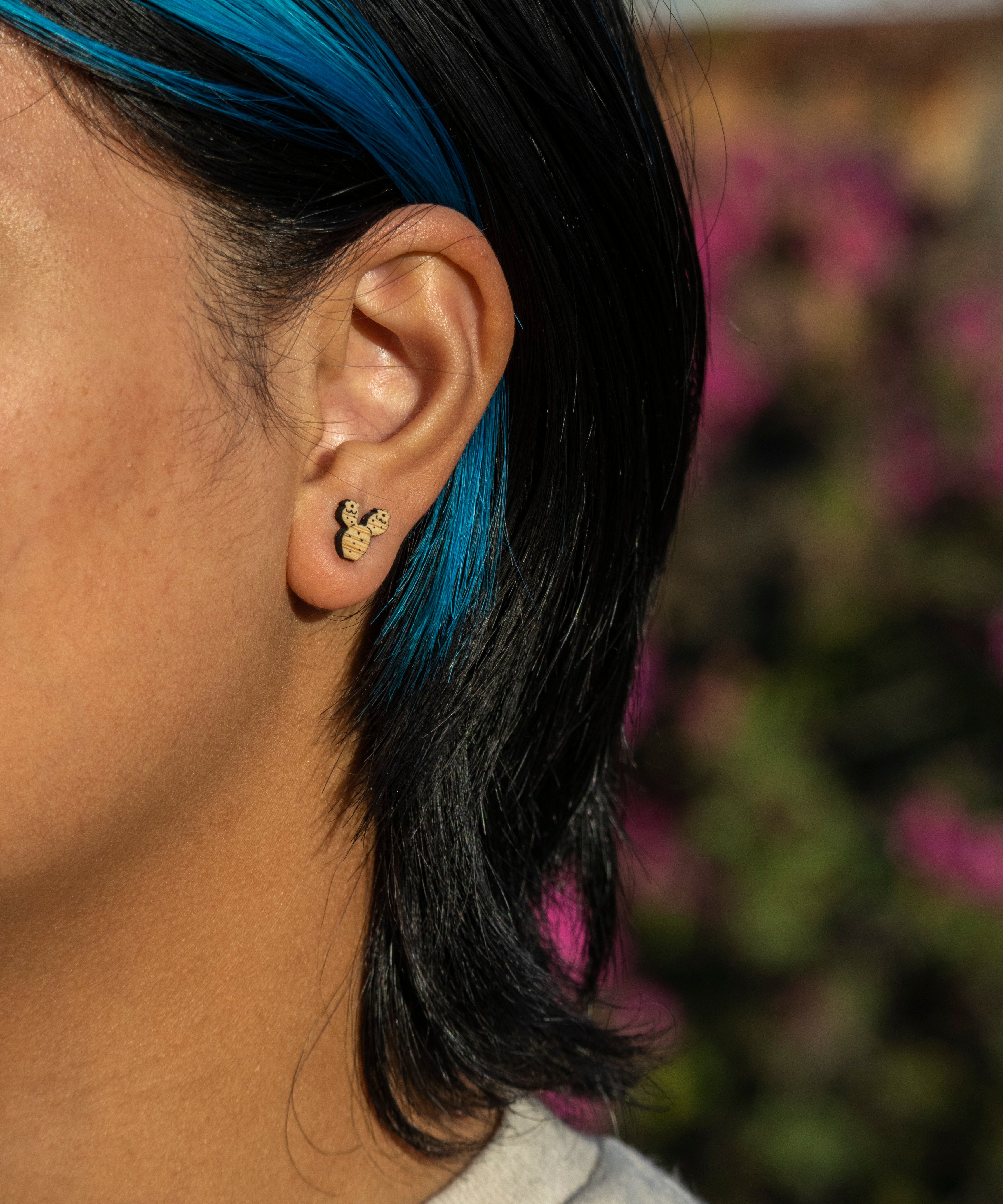 prickly pear stud earring worn by person on natural background